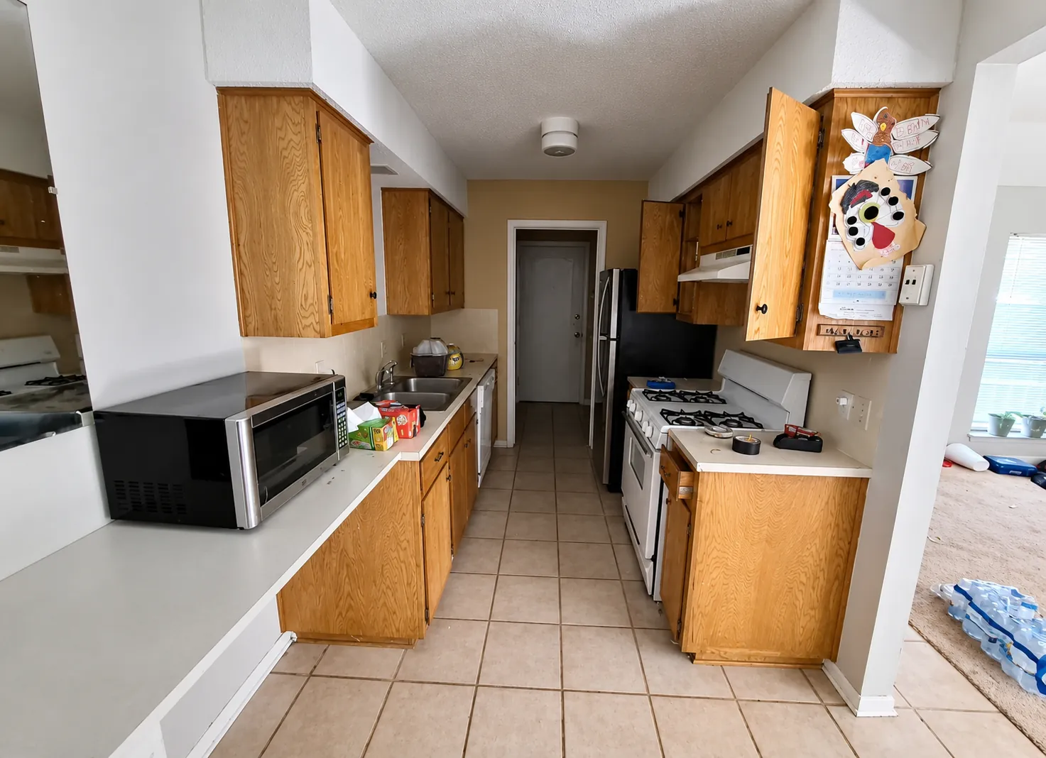 Before renovation: an older kitchen with wood cabinets and tile flooring