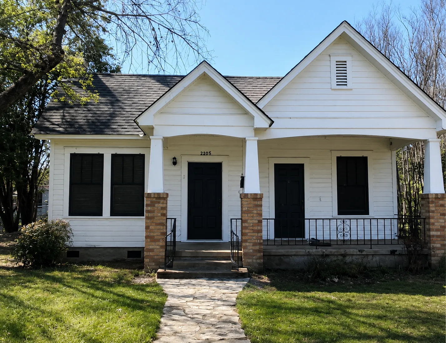 Before renovation: two-unit home with a porch and masonry details